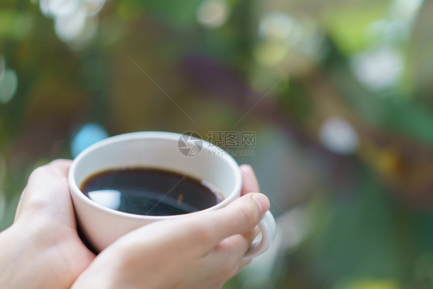 新鲜的马克杯松弛白热饮放在花园的焦点手指上在园艺中心手指上图片