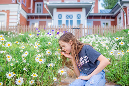 春天过敏金发女孩小在院子里摘花小金色女孩在一片充满甘菊的草地上摘花快乐的图片