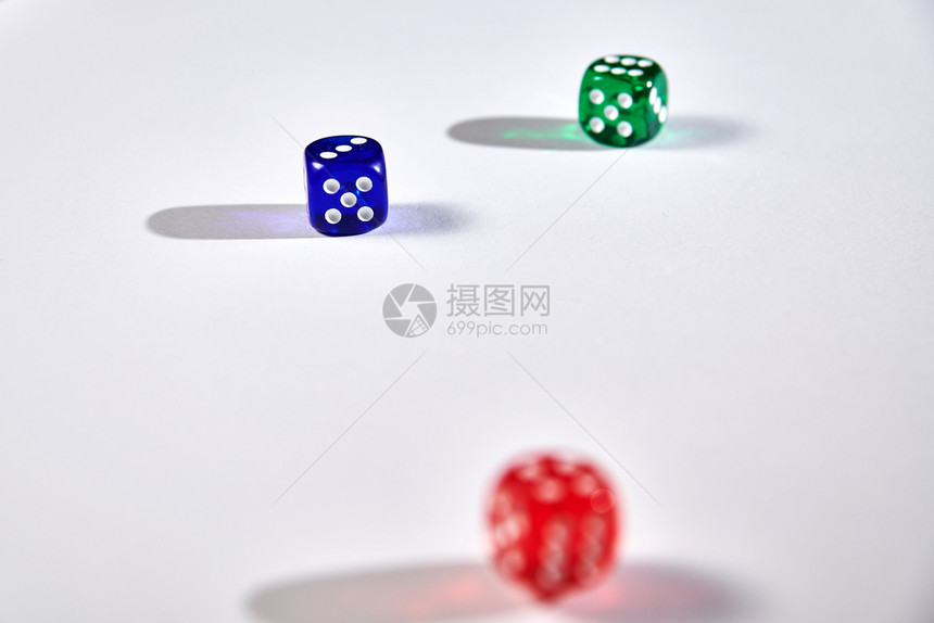 赌注模糊失败者在白色背景上运行的彩色骰子图片