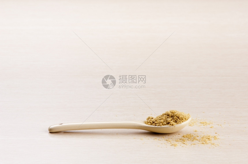 自然木制的调味品地面Coriander在一个勺子里些爬在木制背景上图片