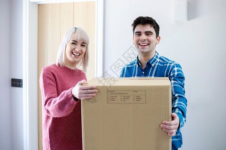 门搬家当天年轻夫妇携带箱子进入新家的肖像微笑屋图片