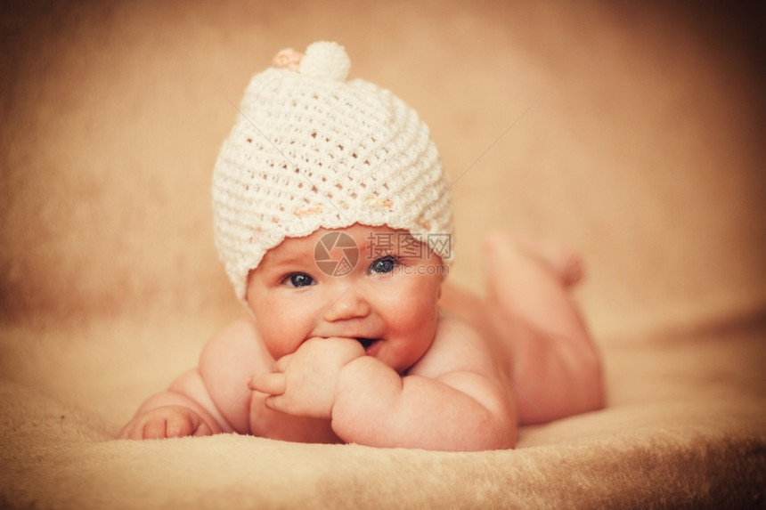 在床上戴白帽子的新生女婴平静脸孩图片