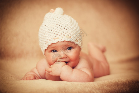 在床上戴白帽子的新生女婴平静脸孩图片