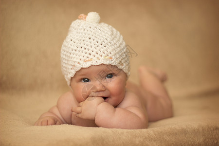 在床上戴白帽子的新生女婴眼睛肖像美丽的图片