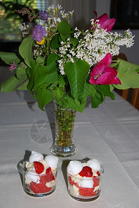花束一种两杯加草莓甜点的两杯放在桌边装饰着一束夏花烹饪图片