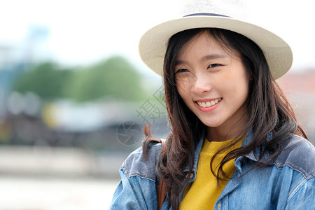 沟通在城市户外背景中微笑的年轻亚洲女临时生活者旅行博客兼游快乐的现代图片