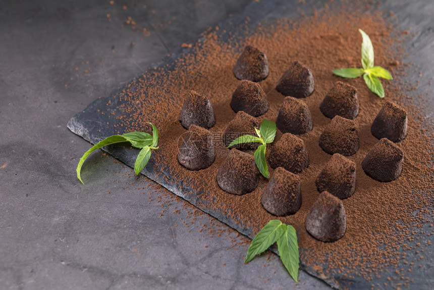 奶油食谱新鲜的土制巧克力松露片薄荷洒上可粉涂在石板上将焦点放在叶子上图片