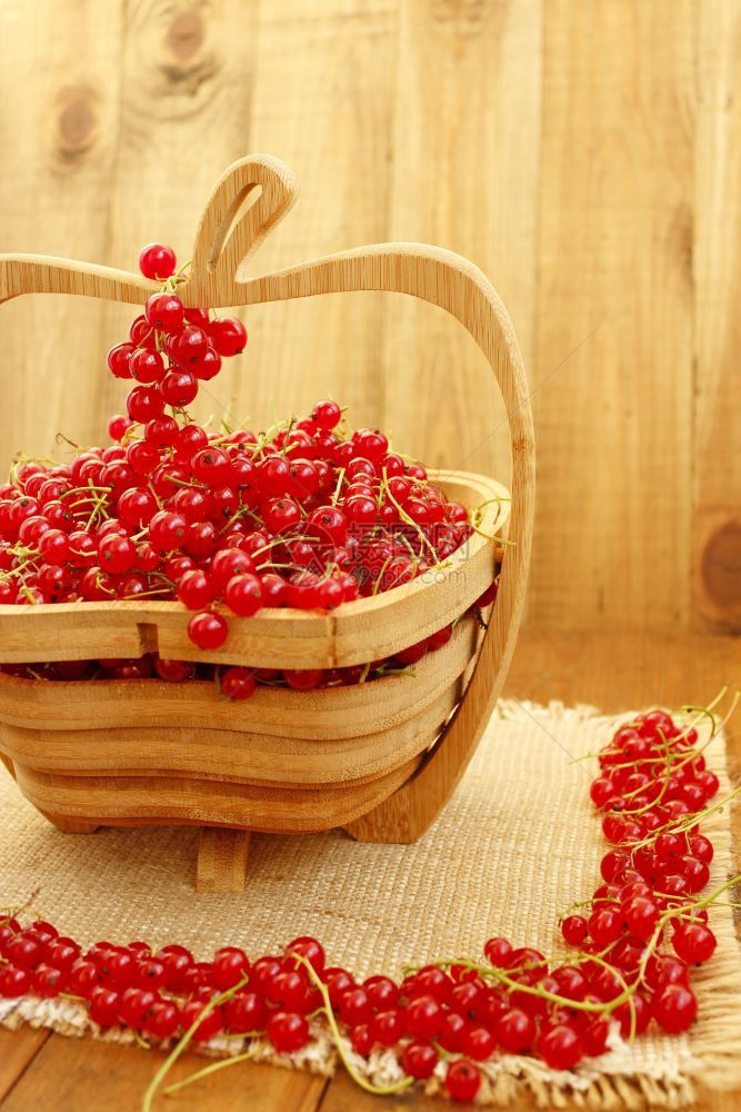 一顿饭庄稼盘子木花瓶上的红醋栗木花瓶上新鲜成熟的红醋栗浆果簇图片