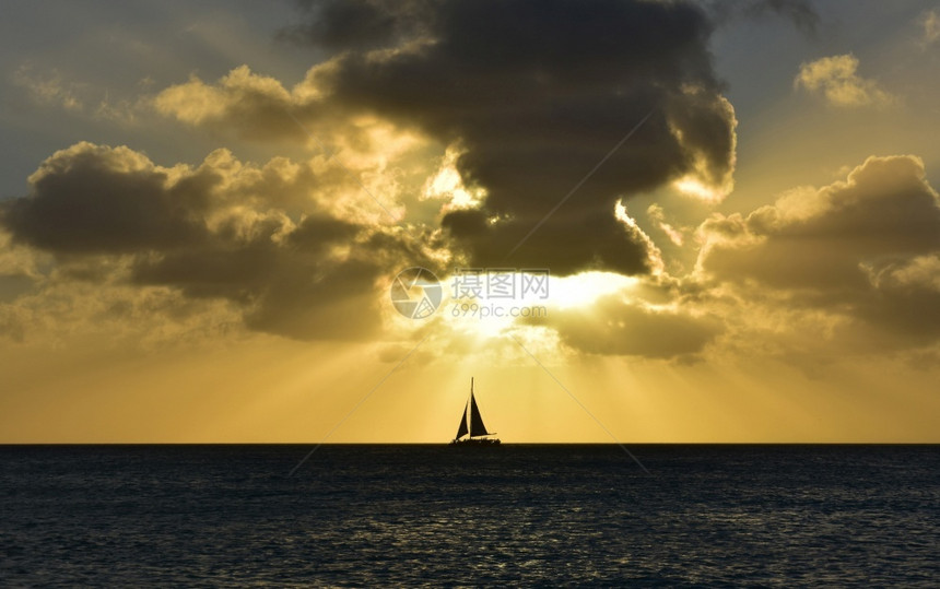 橙日落景观美丽的天空在阿鲁巴的黄昏有一艘轮尾帆船图片
