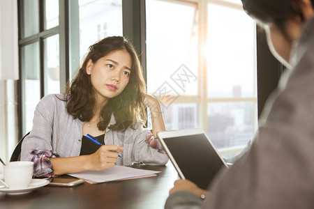 面试人员测评表在办公室工作桌上遇到严重问题的女工作人员团队会议在办公室工作表上亚洲人桌子写背景