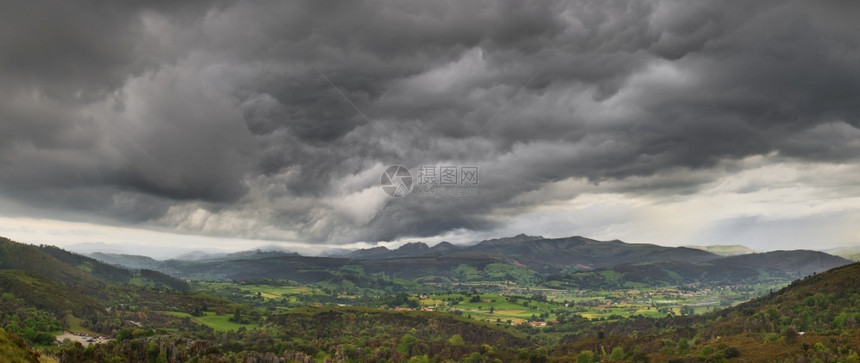 景观西班牙坎塔布里亚的一个绿峡谷上乌云笼罩着黑暗的暴风雨多云气象图片