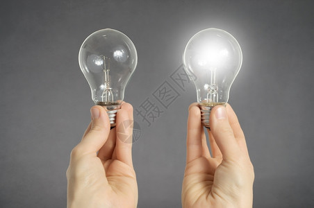 保持手两个灯泡其中一在发光手持两个灯泡其中之一正在发光明可再生图片