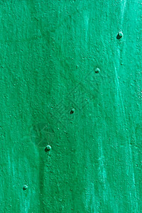 老的乱在明亮阳光下涂有绿色和颜的对角线上带刺状金属板的粗糙图片