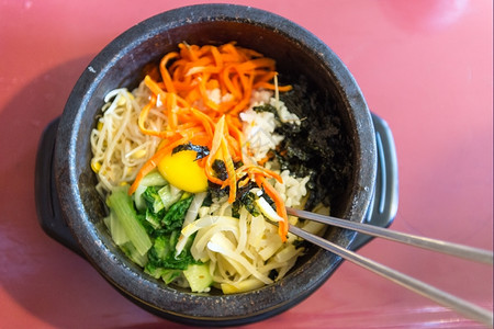 宾堡集团加尔比萝卜一个热石碗中的比宾巴一个配有鸡蛋和新鲜蔬菜的标志韩国盘结石背景