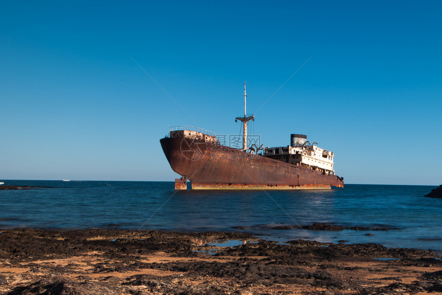 热带海景平静的西班牙加那利群岛兰萨罗特海岸搁浅的老生锈船图片