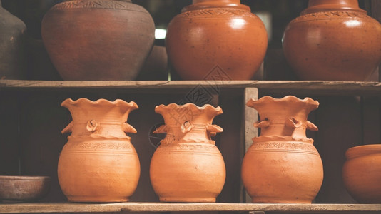 在木架上用古代音调风格的粘土陶器列市场罐架子图片