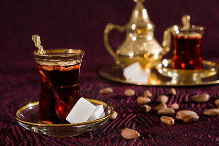 突尼斯人棕色的喝金传统玻璃中突尼斯茶与传统玻璃中的松子突尼斯茶特写背景
