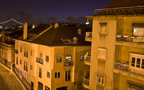 街道夜幕在里斯本的屋顶上葡萄牙河图片