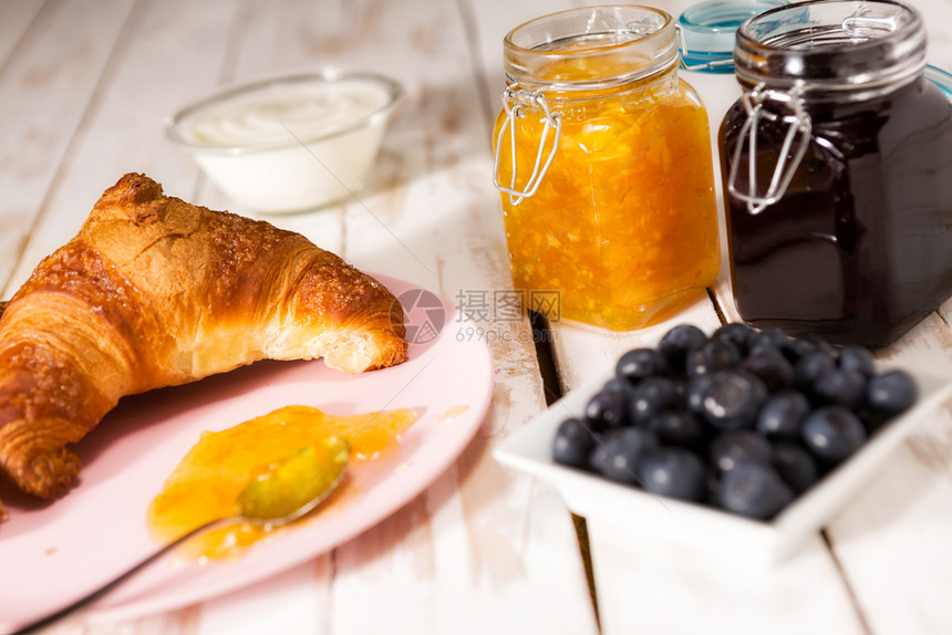 乡村早餐面包蓝莓酸奶橙子和蓝莓果酱在木制桌边吃早餐羊角面包在木制桌边吃早餐罐大陆图片
