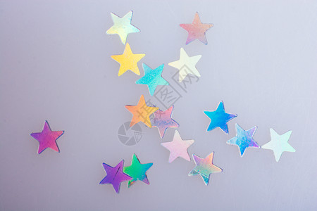 蓝布背景上的恒星形状亮光纸五彩屑狂欢魔法图片