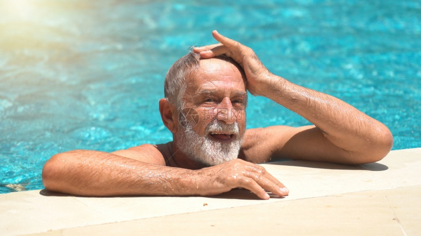 水池蓝色的男老年子在户外游泳池图片