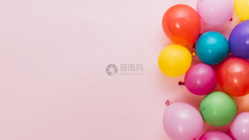 粉色背景上的多彩气球图片