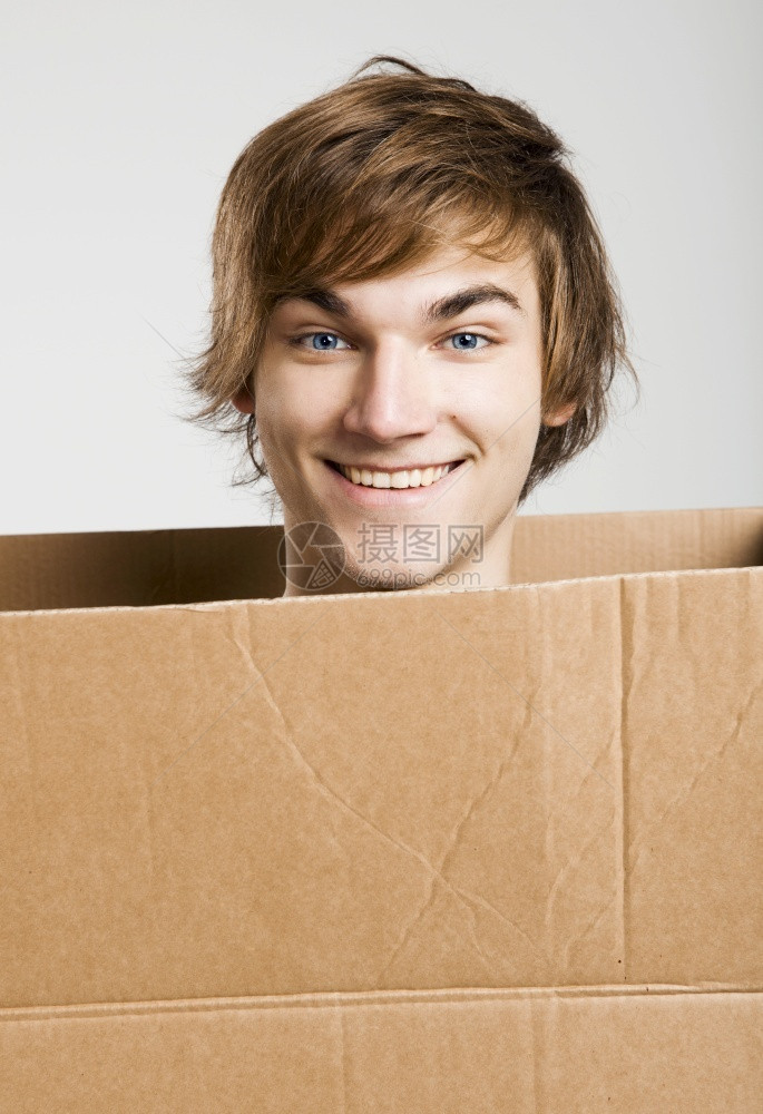 受限的男一个英俊年轻人在纸箱里的肖像爆头图片