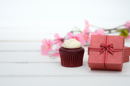 粉彩礼品盒和纸杯蛋糕放在有抄写空间的网状表格背景上浪漫空白的图片