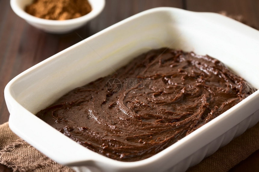 或者棕色的生基本自制布朗尼或巧克力蛋糕面团用油粉和烘烤锅糊贴在黑木上以自然光拍攝选择焦点图像聚三分之一图片