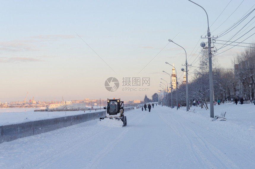 路面小型推土机从俄罗斯Arkhangelsk北Dvina人行道堤岸上取下雪的天气图片