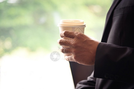 喝商人拿着白纸咖啡杯背景模糊手持白色咖啡杯现代的工作图片