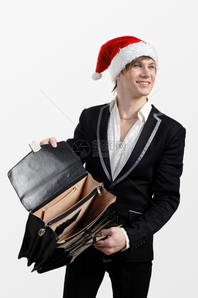 工作室行李白色的年轻男人拿着空公文包戴圣诞老人的帽子在白色背景上图片