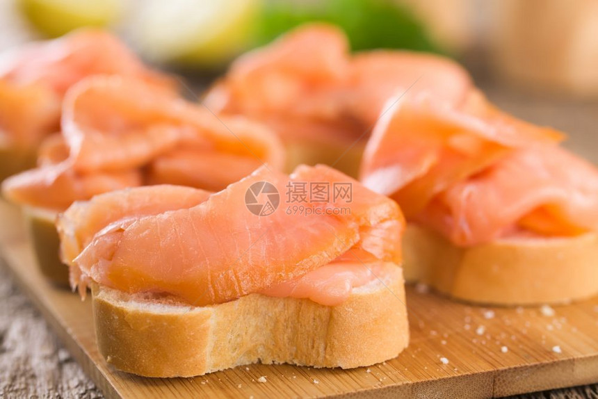 开胃菜木板有选择焦点第一块鲑鱼肉切片的三分之一聚焦在巴格特上的烟熏鲑鱼粉中一顿饭治愈图片