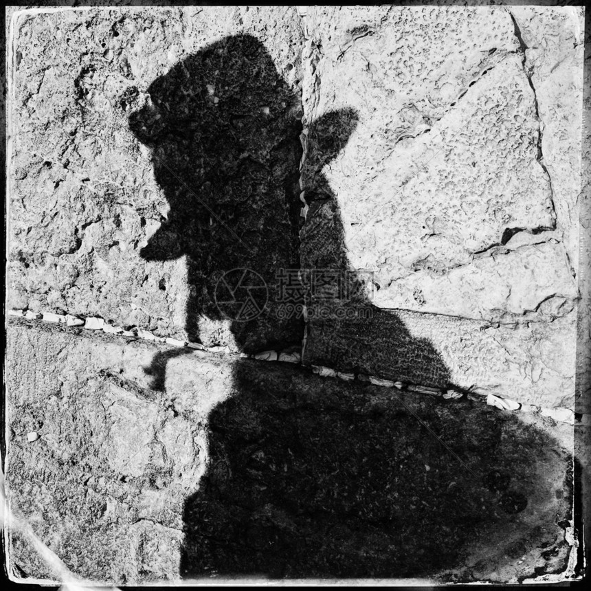 老的结石祷告在以色列耶路撒冷旧城的哭墙上一片漆黑的阴影下一名观察犹太祈祷的教徒在一块废墙上图片