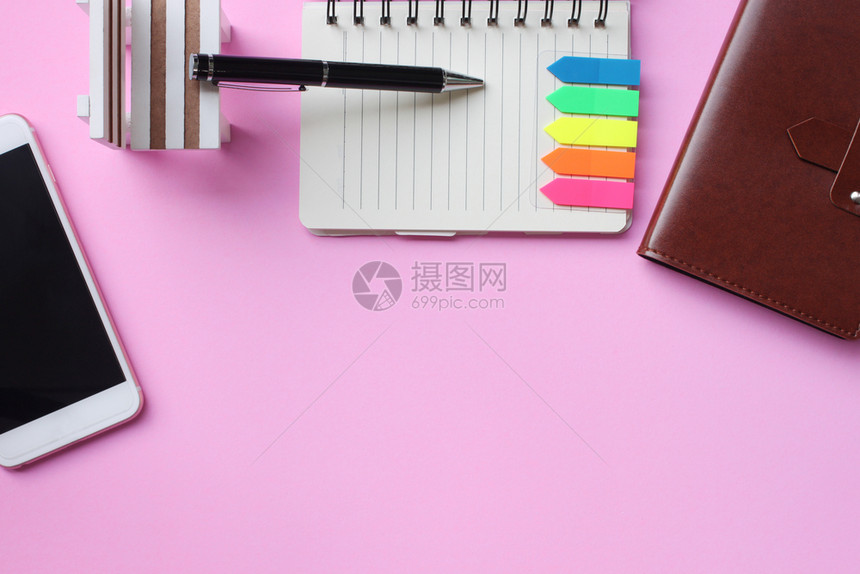 空白的工作笔记本和智能手机放在粉红色的地板上在您作品中复制空间干净的图片