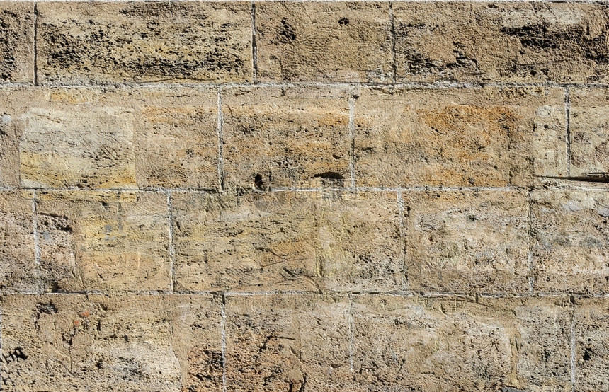 不均匀的肮脏石工光滑棕褐椰子树块墙的纹理图片