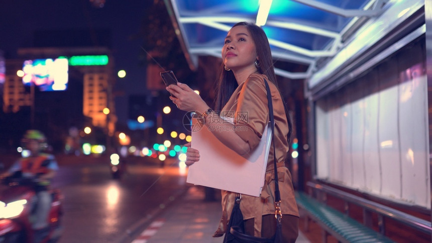 散景年轻的亚洲女商人晚上在市街叫计程车户外人们图片