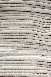 整齐地折叠桩许多干净的白毛巾整齐地堆叠在一起洗过桩棉布背景