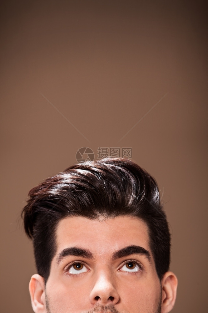 离开严肃的垂直在棕色背景上穿着大发型的半个男人头图片