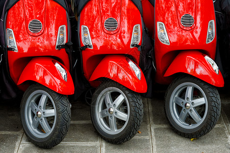 优质的城市滑板车三辆红色摩托按行排列停在户外靠的三辆红色摩托车图片