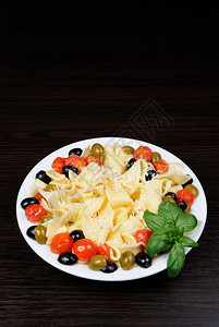 吃帕尔马干酪饮食的配有橄榄大蒜烤肉和西红柿的意大利面粉配有帕米桑干酪图片