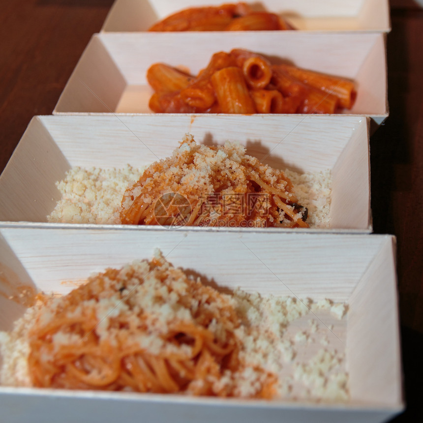 面条和帕米桑奶酪意大利面和里加多尼在小矩形白底盘内有番茄酱午餐长方形拉古图片