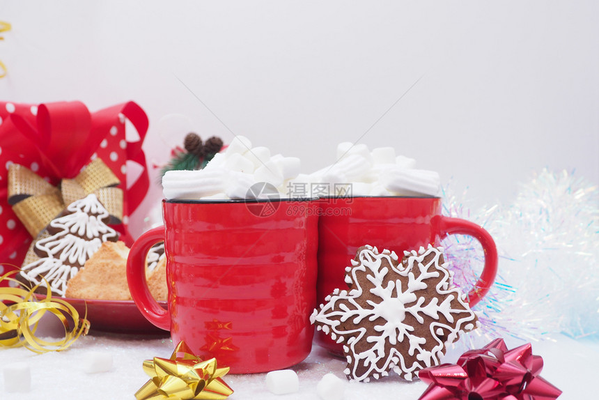 家波尔卡两个红杯子加咖啡和棉花糖姜面包饼干加冰雪花和圣诞树丝带罐头白底弓等冰淇淋假期图片