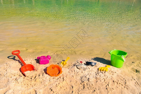 童年乐趣放松沙滩上像桶和铲子一样的塑料玩具图片