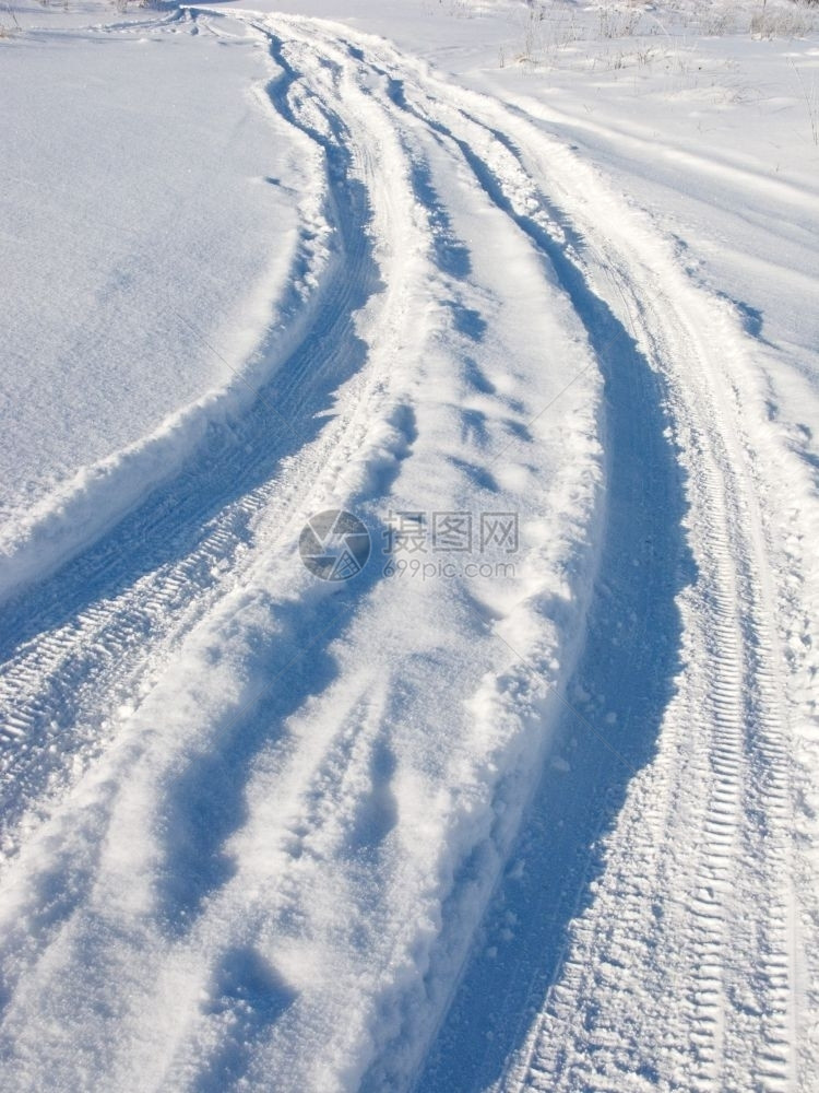 脚印阳光明媚的冬日田野雪轨小路土地图片