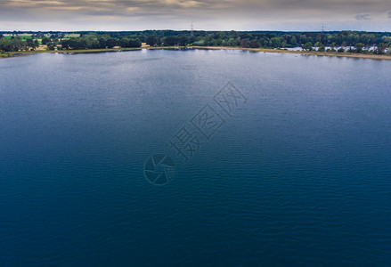 低的高度空中观视从一个带蓝水的低空深湖一片森林地带和用无人驾驶飞机制造的地平线上惊人天空无机图片