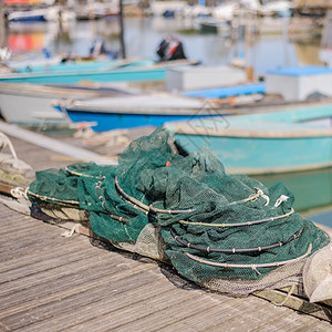 鱼海浪码头上的渔网底是船的网浮标背景图片