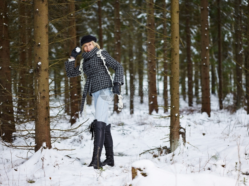 雪身着冬衣农村风景背森林的时装成熟年妇女天一月图片