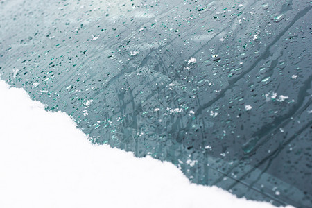 雨加雪冷冻水若冰霜雪和玻璃上的雨滴作为背景设计图片