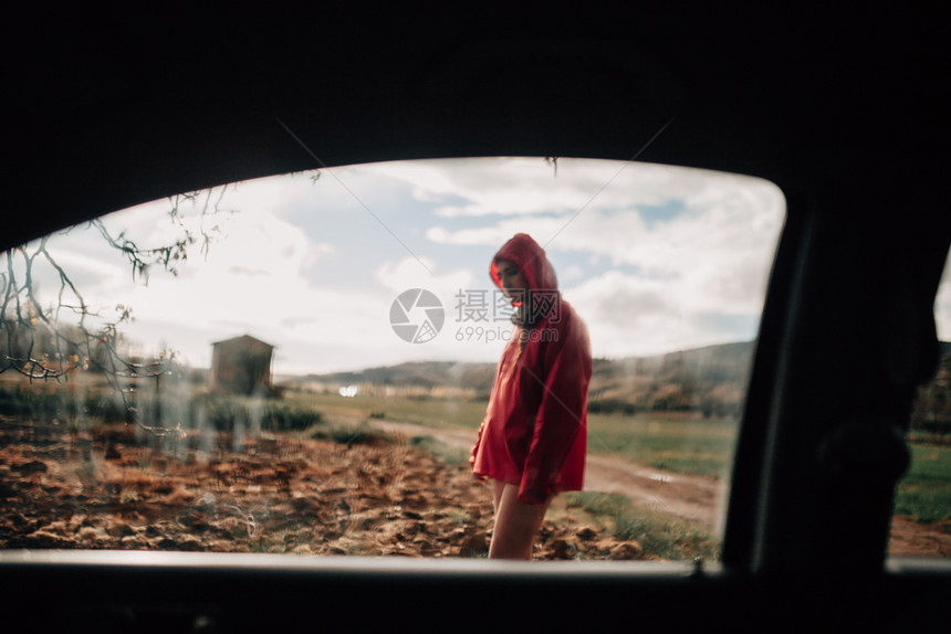 多云的自然从一个年轻的女车里面观看外的雨天在田野上编织图片